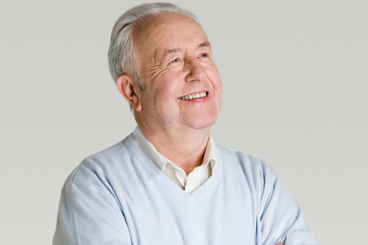 A senior man smiling confidently with well-fitted dentures.