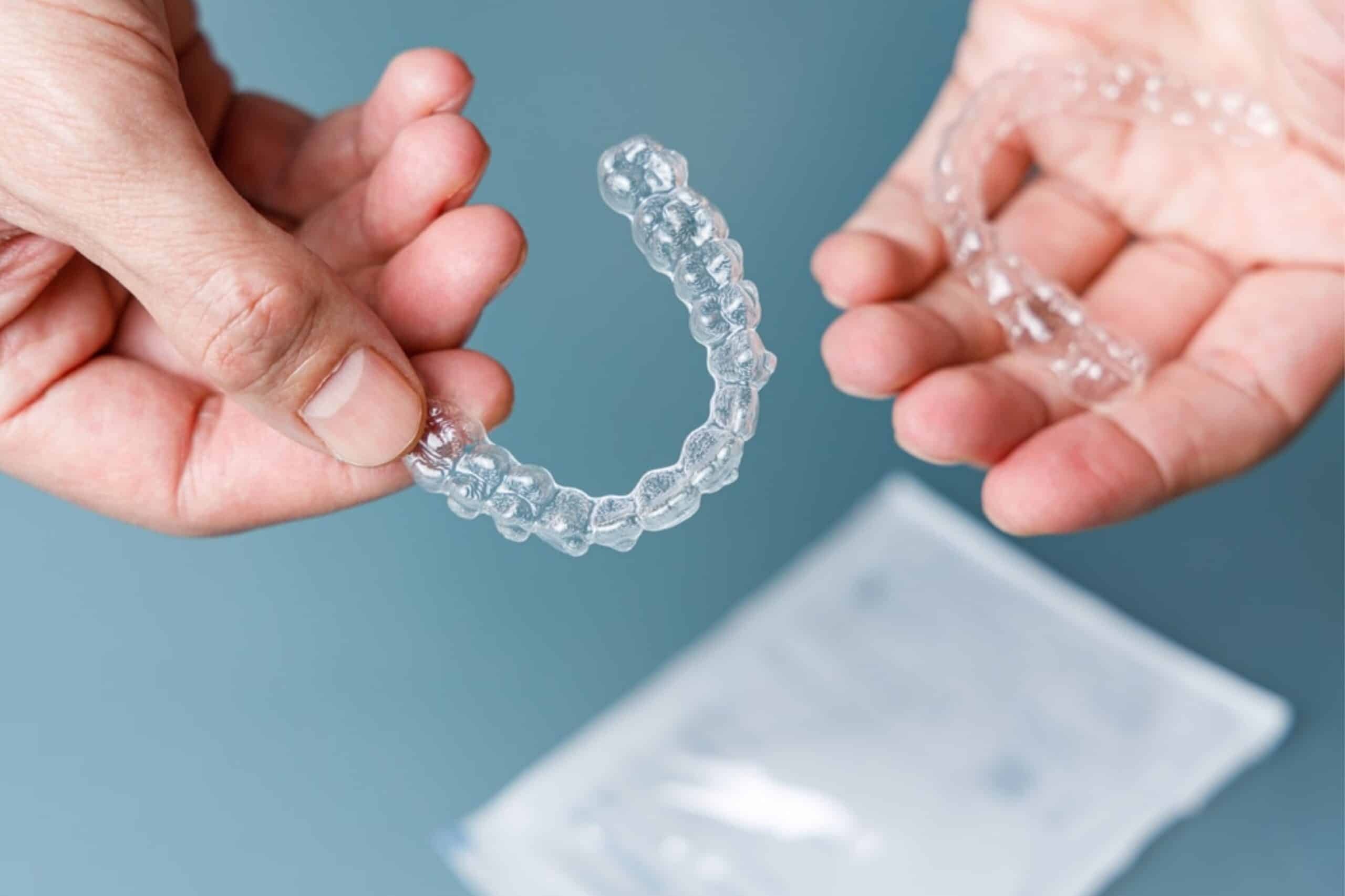Hands holding Invisalign clear aligners for orthodontic treatment in Paradise Valley, AZ